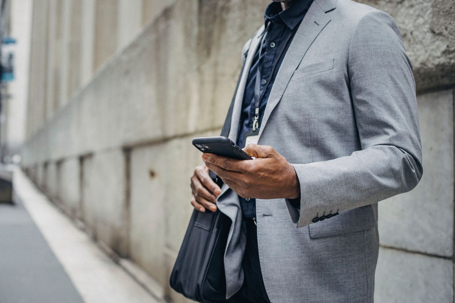 A businessman checking his phone on the street